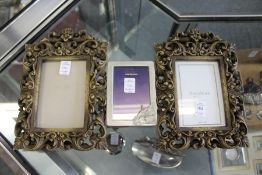 A pair of decorative photograph frames and another frame.
