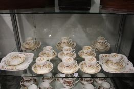 A part tea service decorated with birds on a branch.