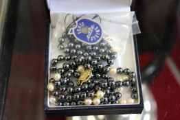 A black and white pearl necklace with 9ct gold clasp.