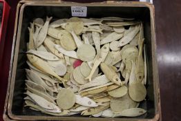A quantity of Chinese bone fish shaped and other counters in a lacquer box.