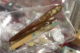 A bag of coins, watch movements, letter openers and a fan.