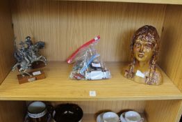 Two cast metal figures, toy cars and a pottery bust of a young girl.