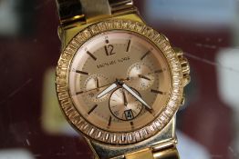 A Michael Kors rose gold coloured chronograph style wristwatch.