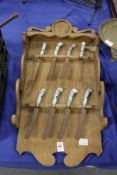 An unusual Dutch oak rack containing eight Dutch Delft porcelain handled knives.