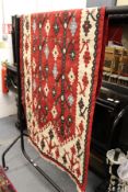 A small Kilim flat weave rug, red ground with stylized decoration.