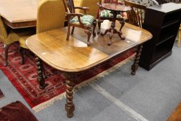 An oak extending dining table on barley twist legs.