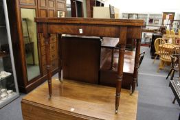 A George III mahogany D-shaped foldover card table on turned legs with brass castors.