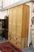 A large Victorian and later pine three door cupboard, the base with four drawers.