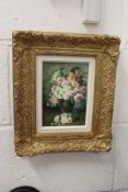 A still life of flowers in a vase, oil on board, in a decorative gilt frame.