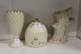 A Belleek porcelain honey jar modelled as a bee skep, together with a rootwood style vase and