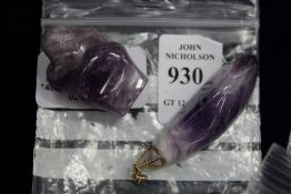 An amethyst pendant and a carved amethyst figure.