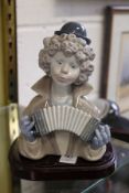 A Lladro bust of a clown playing an accordion.
