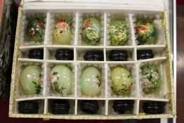 A boxed set of ten Chinese painted jade eggs on stands.
