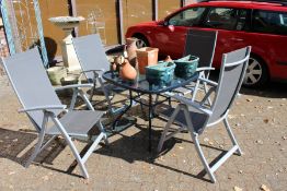 A garden table and four folding chairs.