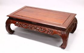 AN EARLY 20TH CENTURY CHINESE CARVED HARDWOOD COFFEE TABLE, with a carved frieze and curving legs,