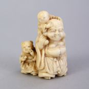 A JAPANESE MEIJI PERIOD CARVED IVORY NETSUKE OF HOTEI, stood with a young boy upon his back and