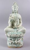 A LARGE CHINESE CELADON CARVED PORCELAIN FIGURE OF GUANYIN, in a seated position upon lotus with