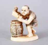 A JAPANESE MEIJI PERIOD CARVED AND STAINED IVORY OKIMONO - BARREL MAKER, the figure carved to depict