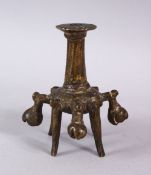 AN ISLAMIC BRONZE CANDLESTICK OR JOSS STICK HOLDER, on four feet with 5 ringing bells, 10cm high