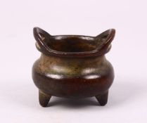 A GOOD CHINESE MINIATURE BRONZE TRIPOD CENSER, The censer with twin handles and the base bearing a