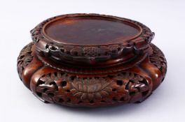 A GOOD 19TH CENTURY CHINESE CARVED HARDWOOD STAND, carved with sceens of flora, 32cm diameter ,