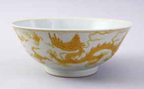 A CHINESE YELLOW INCISED PORCELAIN DRAGON BOWL, the base with a six character mark to base, 19cm.