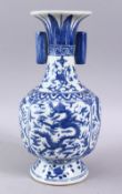 A CHINESE BLUE & WHITE PORCELAIN MING STYLE VASE, decorated with dragons amongst clouds, with twin