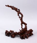 A GOOD CHINESE CARVED HARDWOOD NATURALISTIC ARCHED STAND, 26cm high x 24cm wide.
