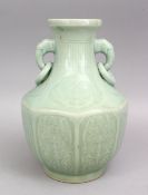 A GOOD CHINESE CELADON MOULDED PORCELAIN TWIN HANDLE VASE, the body of octagonal form with carved