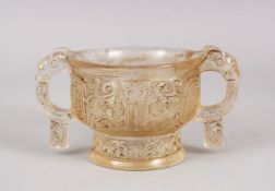 A CHINESE CARVED GLASS TWIN HANDLE CUP, decorated in archaic form with elephant head mask handles,