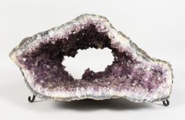 A LARGE AMETHYST GEODE on a wrought metal base. 15ins.