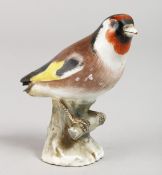 A 19TH CENTURY MEISSEN BIRD on a branch. Cross swords mark in blue. 3.5ins high.