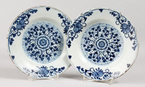 A PAIR OF 18TH CENTURY DELFT PLATES, painted with a central flower.