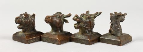 A SET OF FOUR CHINESE BRONZE ANIMAL HEAD SEALS depicting animals of the zodiac. 1.5ins high.