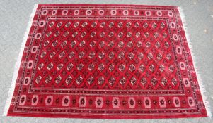 A GOOD LARGE MODERN BOKHARA CARPET, claret ground with six rows of fourteen gulls. 12ft 10ins x