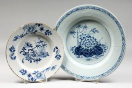 A LARGE 18TH CENTURY DELFT PLATE, painted with a water lily and bamboo surrounded by a cross hatched