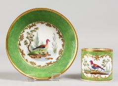 A GOOD SEVRES CUP AND SAUCER, green ground painted with birds. Mark in blue, Letters GG.