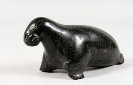 AN INUIT CARVED HARDSTONE GROUP OF A SEAL. Etched on base E.S. 1749. 6ins long.