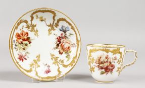 A LATE 18TH CENTURY BERLIN COFFEE CUP AND SAUCER, painted with flowers and decorated with raised