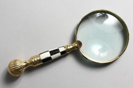A LADIES MAGNIFYING GLASS with chequered and brass handle.