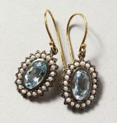 A PAIR OF 9CT GOLD AND SILVER, BLUE TOPAZ AND PEARL EARRINGS.