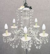 A VENETIAN STYLE CUT GLASS FIVE-BRANCH CHANDELIER, with scrolling arms and cut glass prism drops.