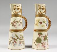 A PAIR OF ROYAL WORCESTER IVORY CLARET JUGS, gilded and painted with flowers on an ivory ground,