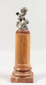 A GOOD SILVER PLATED CUPID on a marble column. 13.5ins high including column.