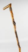 A JAPANESE CARVED RHINO HANDLE WALKING STICK, carved with frogs and alligator. 35ins long.