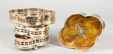 A SET OF FOUR SHAPED FAUX TORTOISESHELL WINE COASTERS.