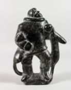 AN INUIT CARVED HARDSTONE FIGURE OF AN ESKIMO.