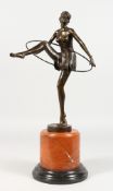 AN ART DECO STYLE BRONZE FIGURE OF THE HOOP DANCER, on a circular marble base. 19ins high.