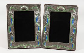 A PAIR OF ART NOUVEAU STYLE SILVER AND ENAMEL PHOTOGRAPH FRAMES. 7.5ins x 5.75ins.