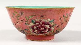 A CHINESE PORCELAIN BOWL, pink ground painted with flowers. 6.5ins diameter.
